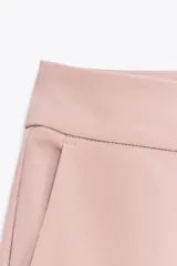 Pantalón verde oliva de tiro alto confeccionado en mezcla de viscosa, con bolsillos delanteros y falsos bolsillos de vivo en la espalda. Tiene pernera recta y cierre frontal con cremallera, botón interior y gancho.