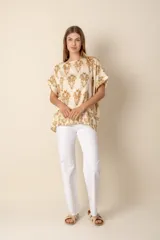 Blusa estampada de lino color crema con estampado cachemir en tonos dorados, de manga corta y cuello redondo.