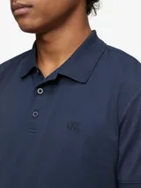 Chomba azul marino de manga corta, con cuello clásico y tapeta de dos botones. Logo de Calvin Klein bordado en el pecho.