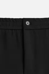 Pantalón negro de corte recto con cintura elástica, bolsillos laterales y un bolsillo trasero de ojal.