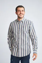 Camisa de hombre de manga larga con estampado a rayas verticales en tonos azul, blanco y beige. Tiene fit slim, cartera abotonada y logo bordado en el pecho. Confeccionada en algodón.