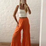 Pantalón palazzo naranja con elástico en la cintura y diseño escalonado con volados.