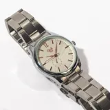 Reloj de pulsera Luthiel con correa de acero plateado y esfera blanca con agujas y marcadores de hora dorados.