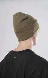 Gorro de lana color verde militar, con logo de la marca en etiqueta negra cosida en el frente.