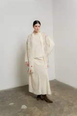 Bufanda larga de tejido de punto color crudo con diseño calado y pequeños detalles de color en forma de puntos.