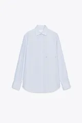 Camisa de cuello solapa y manga larga con puño doble abotonado. Cierre frontal con botones y estampado a rayas verticales rosas y blancas.