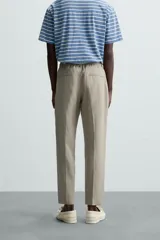 Pantalón de vestir azul marino confeccionado en tejido de lino. Corte recto, con bolsillos laterales y traseros. Se ajusta a la cintura con botón y cremallera.