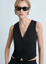 Chaleco negro con cuello en V, sin mangas y cierre frontal con botones.