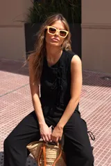 Pantalón negro de tejido ligero, corte holgado, cintura elastizada y aberturas laterales con lazos.