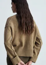 Sweater color beige de tejido de punto con cuello redondo y mangas largas.