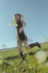 Vestido corto marrón de gamuza sintética, sin mangas, con escote en V y detalle de flecos en el ruedo. Presenta apliques bordados en el frente y laterales.