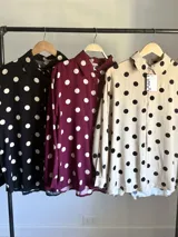 Camisa de manga larga en fibrana color bordó con estampado de lunares grandes en color crema. Presenta cuello camisero y cierre frontal de botones.
