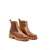 Bota de cuero vacuno color beige, con suela de goma y cierre YKK en el lado interno.