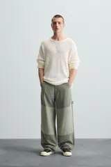 Pantalón de jean color verde con diseño de bloques de color en diferentes tonos de verde, corte amplio, tiro alto, cinco bolsillos y presilla para herramientas en la pierna.