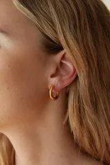 Par de aros tipo argolla gruesos de acero quirúrgico hipoalergénico color plateado.