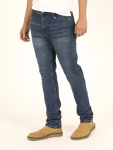 Pantalón de jean azul de corte slim, con 5 bolsillos y lavados de moda.
