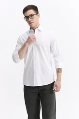 Camisa clásica lisa de manga larga color blanco, con cartera abotonada y logo bordado. Confeccionada en algodón y spandex, de corte slim.