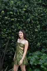 Vestido corto de fiesta color verde esmeralda brillante, con escote strapless, argolla metálica en el busto, breteles finos y cut-outs en el delantero.
