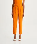 Pantalón cargo de viscosa color naranja, con cintura alta y cierre por enganche doble y botones. Cuenta con bolsillos delanteros, laterales y traseros, y pliegues delanteros.
