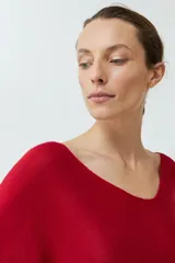 Sweater de punto color rojo, con diseño oversized, escote en V y mangas anchas de estilo murciélago.