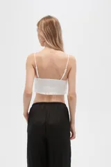 Musculosa blanca de algodón con breteles finos, punto smock, corte al cuerpo y cuello redondo.