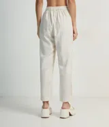 Pantalón fluido color crema, confeccionado en viscolino, con cintura elástica y lazo ajustable.