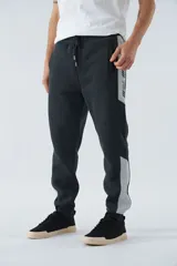 Pantalón de jogging gris oscuro de felpa con puños, cintura ajustable con cordón y logo estampado en la pierna.