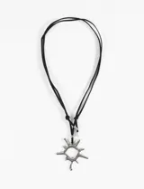 Collar con cordón negro y dije plateado con forma de sol gótico.