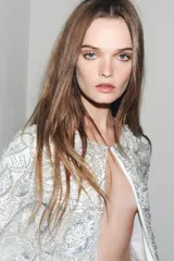 Chaqueta corta blanca con lentejuelas plateadas, cuello redondo, manga larga y forro interior.