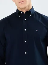 Camisa de popelina azul marino de Tommy Hilfiger, de manga larga, con cuello abotonado, cierre con botones y logo bordado en el pecho.