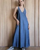 Vestido largo azul melange de corte imperio, con escote en V y breteles finos. Presenta una abertura lateral en la falda.