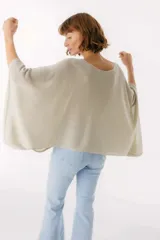 Blusa beige de tejido brillante, con cuello bote y mangas murciélago.