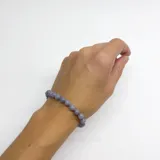 Pulsera elástica de cuentas redondas de ágata celeste de 6mm, con terminales y cierre de acero hipoalergénico dorado.