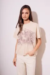 Remera color arena de algodón peinado, corte al cuerpo y estampado frontal con la frase 'Bon Jour' en color lila.