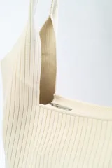 Bolso negro tipo tote bag con textura acanalada y asas de hombro.