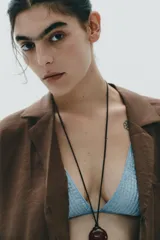Camisa marrón de cuello solapa y escote pico con manga corta. Bolsillos de plastrón en pecho. Cierre frontal con botones.