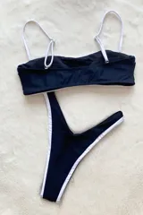 Bikini cavada en dos tonos, negro con detalles en blanco, con forrado interior, relleno desmontable y tiras regulables.