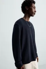 Jersey azul marino de punto, con cuello redondo y manga larga. Tejido en hilatura con mezcla de seda y lino.