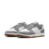 Championes Nike Dunk Bajo Retro SE, color gris y blanco, con detalles en marrón en la suela.