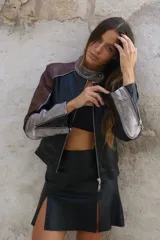 Campera tipo moto con cuello mao en platino suave y combinación de tres tonos de cuero ovino: negro, marrón rojizo y plateado. Forrada con cierres en las mangas.