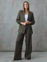 Blazer blanco de lino con cuello con solapa, bolsillos sastre y mangas fruncidas.