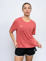 Remera deportiva color coral con logo Umbro estampado en el pecho.