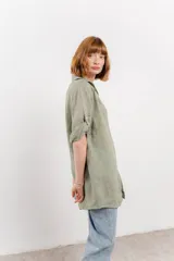 Camisa color beige de lino, con corte recto y calce suelto, cuello camisero, botones en el frente y mangas cortas con presilla y botón.