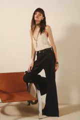 Pantalón de jean negro corte oxford, de tiro medio, con cintura y cadera ajustada y piernas acampanadas. Tejido rígido con proceso de coating que brinda una apariencia similar al cuero.