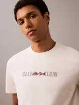 Remera de algodón color beige, de corte regular, cuello redondo y manga corta. Estampado frontal con logo de Calvin Klein en color negro.