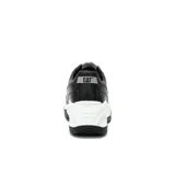 Zapatillas urbanas negras con detalles plateados y suela chunky blanca.