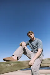 Pantalón de jean celeste de corte amplio, con tiro alto, cinco bolsillos y cierre con botones.