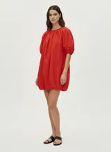 Vestido corto de algodón color rojo, con mangas globo y cuello redondo. Corte suelto y textura liviana.