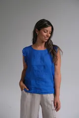Musculosa azul francia de lino con volados en los hombros y botones de nácar en la espalda.