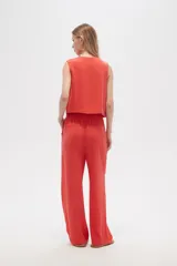 Pantalón de viscosa color beige, de corte ancho y tiro alto, con bolsillos laterales.